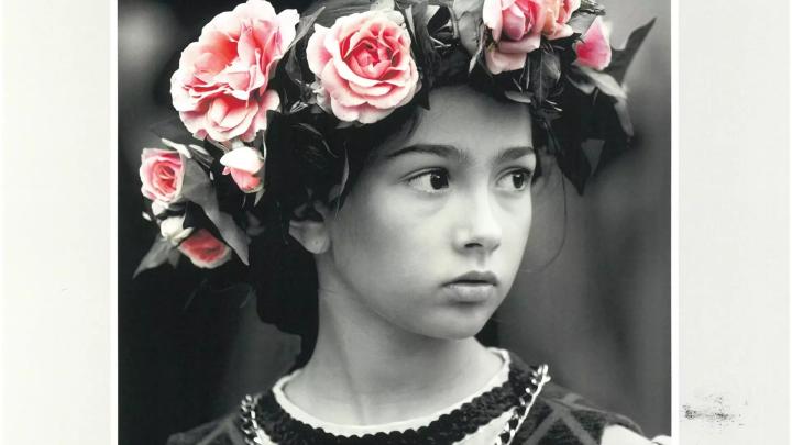 Fotografia con testa di fanciullo in bianco e nero, con ghirlanda di fiori a colori