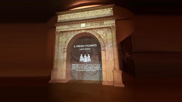 Proiezione dell'Arco di Augusto in una delle nuove sale del museo, con il testo di approfondimento sul fregio figurato del lato ovest.