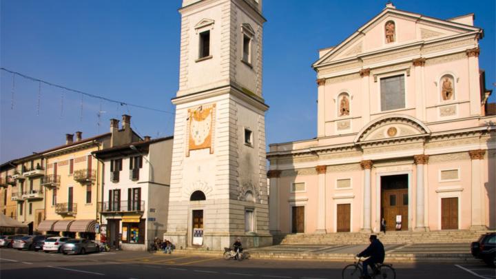 Fotografia si Alessandro Vecchi da Wikipedia: Piazza Dante a Cameri con chiesa parrocchiale e campanile Piazza con chiesa parrocchiale di gusto classicista e grande campanile