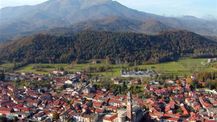 Immagine dal sito del Comune di Chiusa di Pesio Fotografia del comune di Chiusa di Pesio, con chiesa in basso al centro e montagne verdeggianti sullo sfondo