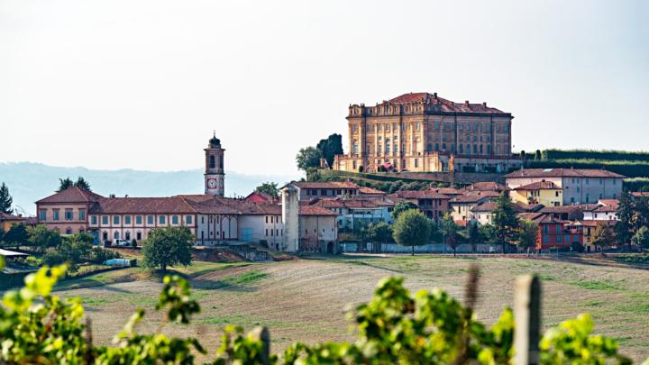 Fotografia di ArtMast92 da Wikipedia: veduta di Guarene dominata dal castello Campi e case dominati da un grande castello settecentesco in mattoni in stile barocco