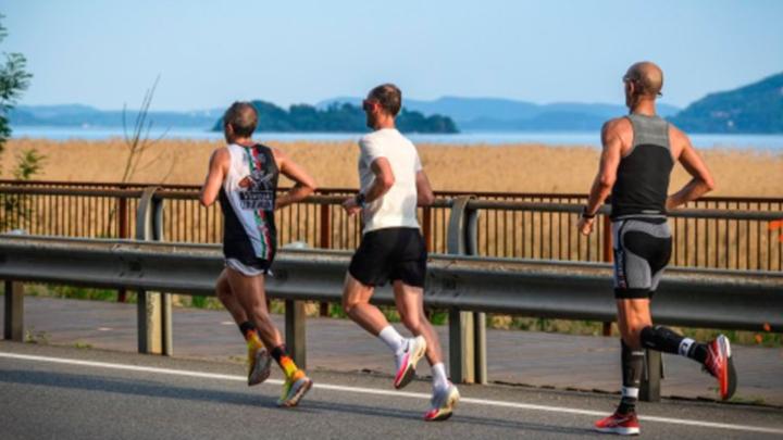 Particolare di foto con tre runner in corsa lungo il Lago maggiore