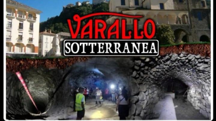 Particolare della locandina di "Varallo sotterranea" edizione 2024 Titolo, foto dell'esterno della Collegiata e di due ambienti sotterranei con visitatori