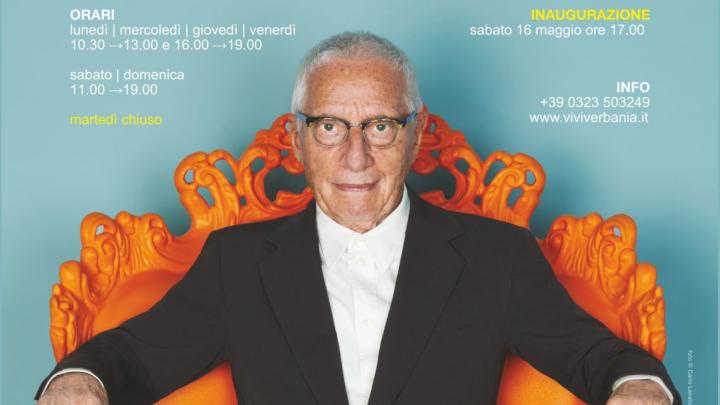 Il designer Alessandro Mendini seduto su una poltrona  a volute di color arancione di sua creazione