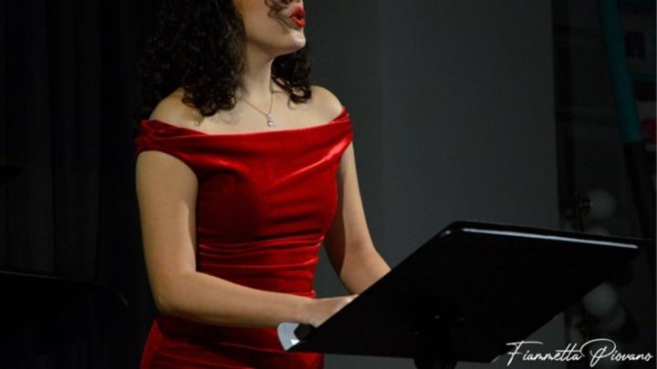 Donna vestita di rosso suona il pianoforte