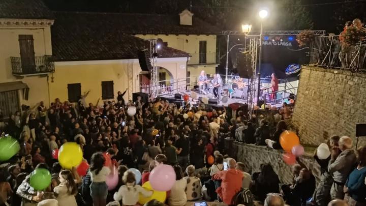 Immagine dal sito www.matariadlanga.it Fotografia di concerto serale in un borgo con numeroso pubblico e palloncini colorati